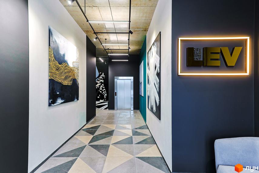 Інтер'єр холу в ЖК ARTHOUSE park з картинами, ліфтом та дизайнерським освітленням. Яскравий приклад архітектурного рішення в новобудові.