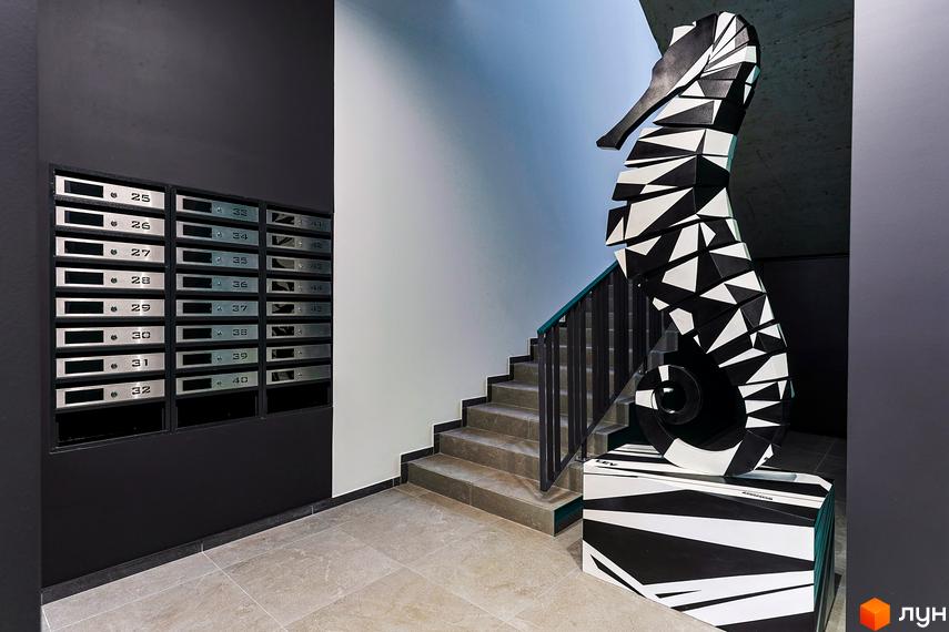 Інтер'єр холу в новобудові. Сходи, поштові скриньки та скульптура у вигляді морського коника.
