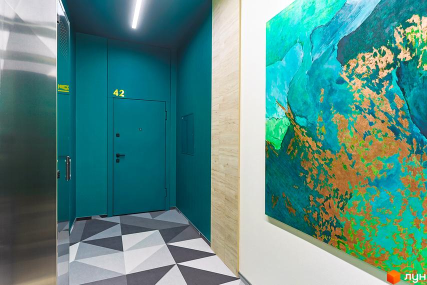 Інтер'єр під'їзду Житлового комплексу ARTHOUSE park: бірюзові стіни, підлога з геометричним візерунком та декоративна картина.