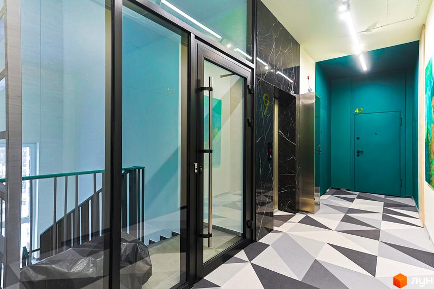Просторий хол в новобудові ЖК ARTHOUSE park з скляними дверима, ліфтом та геометричною підлогою. Яскравий дизайн та сучасні рішення.