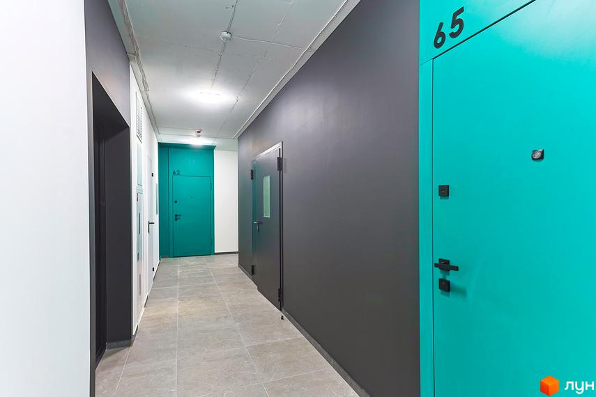 Коридор в новобудові ЖК ARTHOUSE park з дверима бірюзового кольору та сірими стінами, плитка на підлозі.