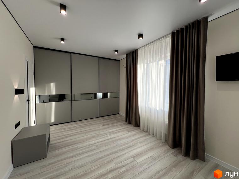 Клубний будинок Васильченка: спальня з великою шафою-купе, шторами та телевізором на стіні. Сучасний дизайн інтер'єру.