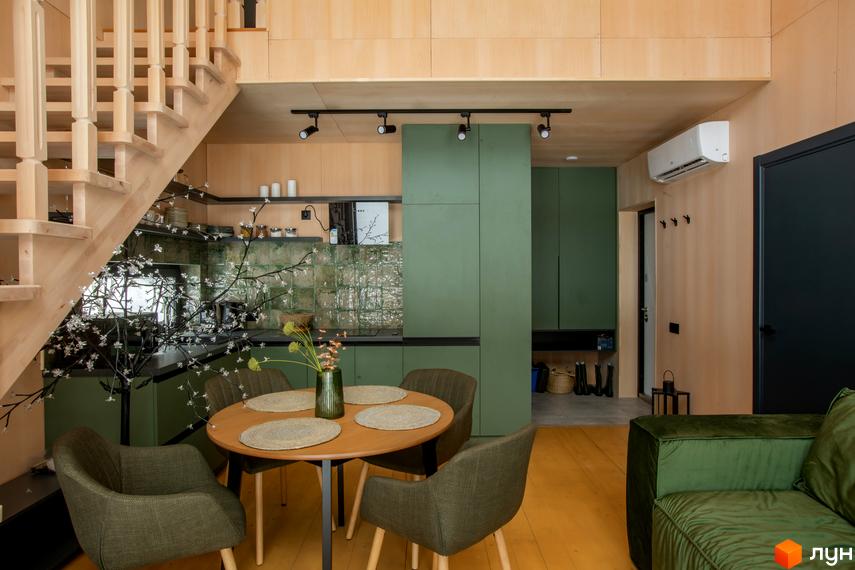 Інтер'єр кухні-вітальні в котеджному містечку КМ TYSHA з дерев'яними елементами та зеленою кухнею. Затишна атмосфера для життя.