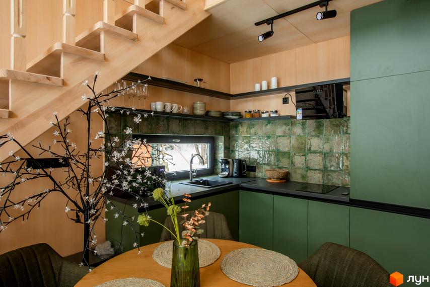 Інтер'єр кухні в котеджі КМ TYSHA з дерев'яними сходами та зеленими фасадами. Затишна атмосфера для життя та відпочинку.