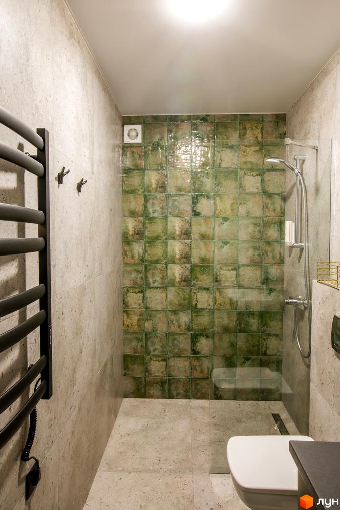 Сучасний дизайн ванної кімнати в новобудові КМ TYSHA з зеленою плиткою та сірими стінами. Ванна кімната обладнана душовою кабіною та білим унітазом.