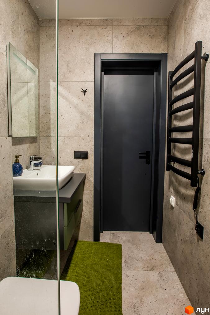 Інтер'єр ванної кімнати у новобудові КМ TYSHA з сірими плитками на стінах, душовою кабіною та дверима.