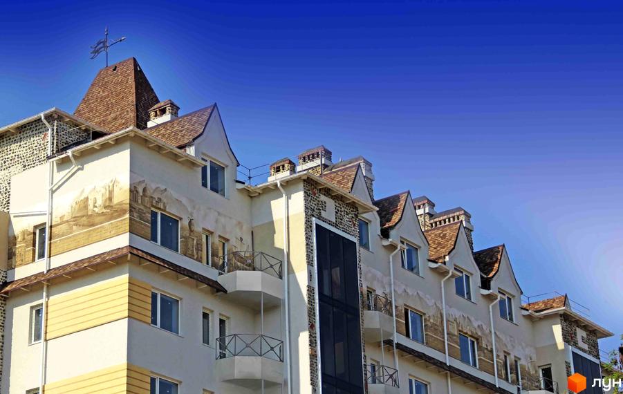 Житловий комплекс Premium Residence у Зеленому Мисі. Фасад будівлі прикрашений муралами та має багаторівневий дах з черепиці та декоративні димарі.