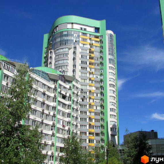 Багатоповерховий будинок Житлового комплексу Паркове місто з вигнутим фасадом, світлими стінами та зеленими елементами. Навколо будинку ростуть зелені дерева.