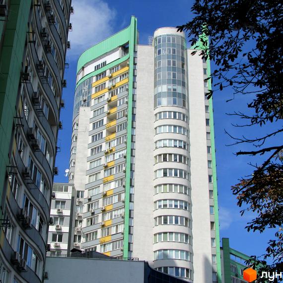 Високі будинки житлового комплексу Паркове місто з фасадами світлого кольору, зеленими та жовтими елементами, та численними вікнами.