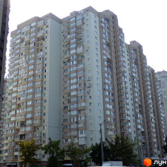 Житловий комплекс Троєщина з висотними будинками та прибудинковою територією з зеленими насадженнями.