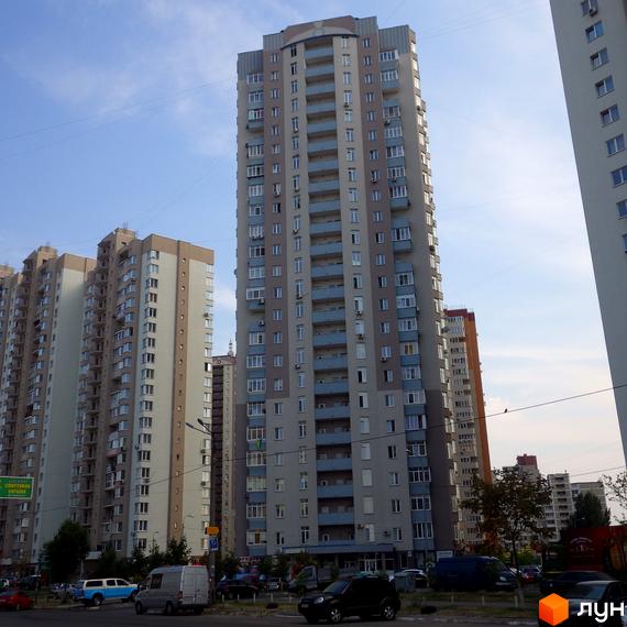 Житловий комплекс ЖК Троєщина з висотними будинками та прибудинковою територією, що включає парковку та зелені насадження.