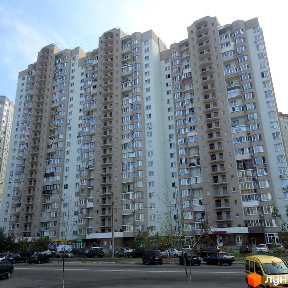 Житловий комплекс Троєщина з багатоповерховим будинком та прибудинковою територією, що включає паркувальні місця.