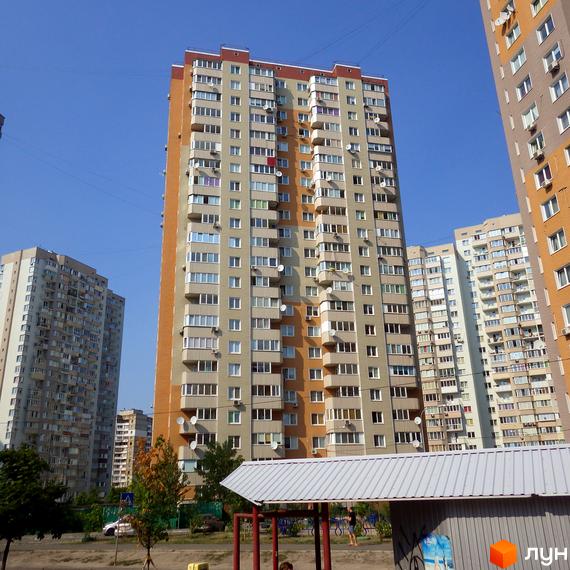 Житловий комплекс Троєщина з висотними будинками та прибудинковою територією, облаштованою для відпочинку.