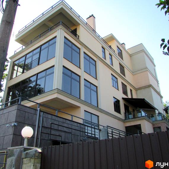 Житловий комплекс Jardan Le Roi з великими вікнами та балконами, прибудинкова територія з огорожею та освітленням.