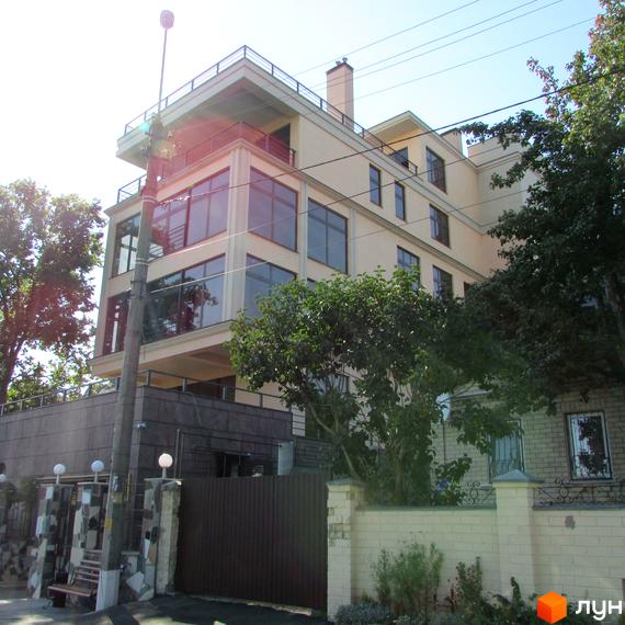 Будинок житлового комплексу Jardan Le Roi з великими вікнами та прибудинковою територією, озелененою деревами.