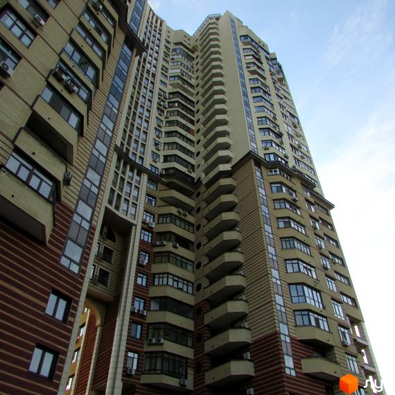 Житловий комплекс на вул. Солом'янська, 15а, з сучасною архітектурою та балконами. Прибудинкова територія з зеленими насадженнями.