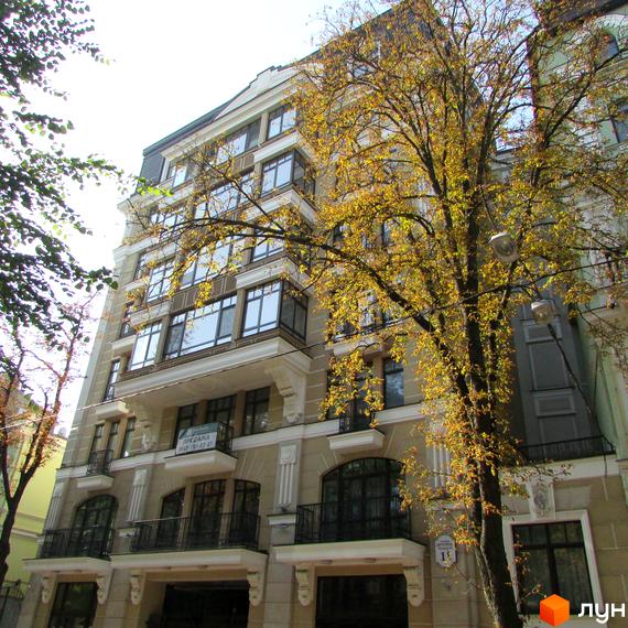 Житловий комплекс на вул. Десятинна, 11, з фасадом з великими вікнами та балконами, оточений зеленими деревами.