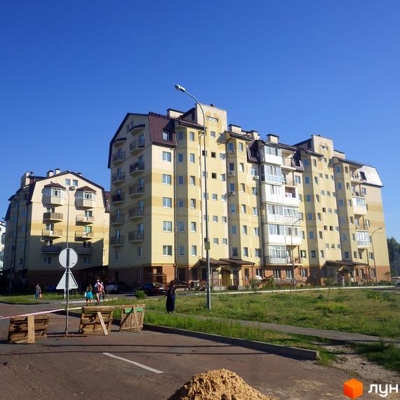 Житловий комплекс на вул. Дяченка з жовтою фасадною обробкою та балконами. Прибудинкова територія з зеленими насадженнями та дорожніми знаками.