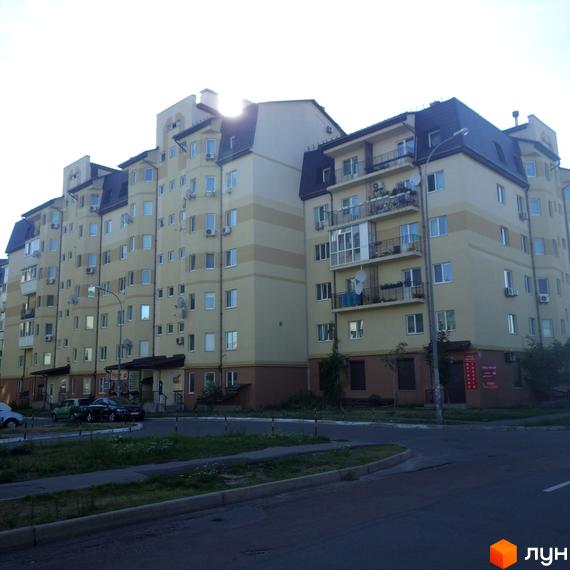 Житловий комплекс вул. Дяченка, 20, 20а, 20б, 20в. Вид на фасад будинку та прибудинкову територію з зеленими насадженнями.