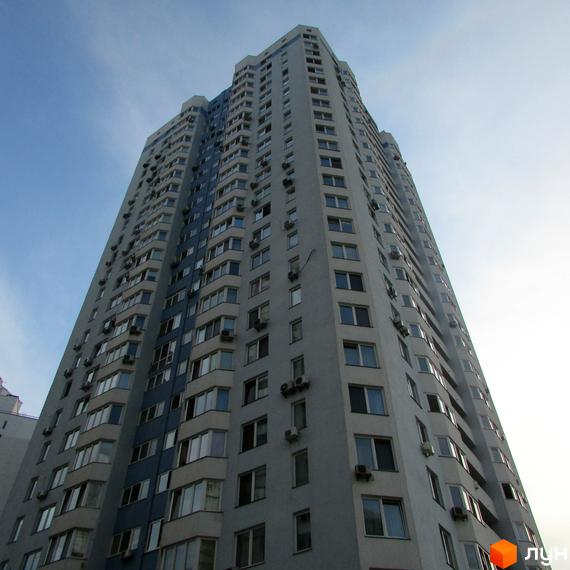 Житловий комплекс на вул. Олени Пчілки, 6, висотна будівля з великими вікнами та балконами. Прибудинкова територія озеленена та облаштована.