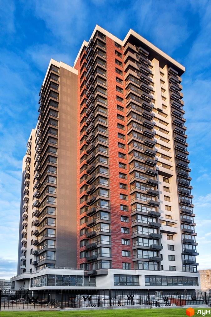 Висотна новобудова ЖК West House з фасадом з червоної цегли та панорамними вікнами. На першому поверсі розташовані комерційні приміщення, територія огороджена парканом.