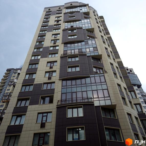 Висока житлова будівля Житлового комплексу Престиж Холл з фасадом з бежевих та темно-сірих панелей, великими вікнами та скляними балконами.