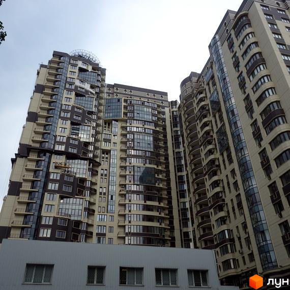 Фасад Житлового комплексу Престиж Холл представлений високими будівлями світлих та темних відтінків. Будинки мають багато вікон та вигнуті балкони.