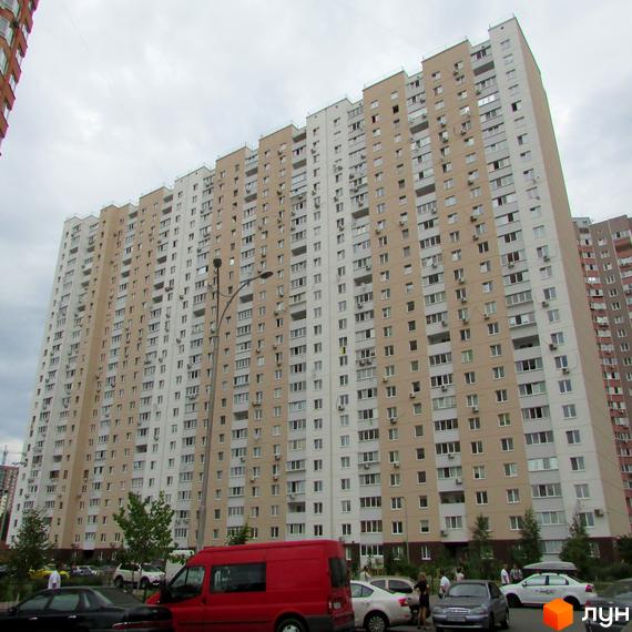 Житловий комплекс на вул. Урлівська, 38, з фасадом у світлих тонах та прибудинковою територією з зеленими насадженнями.