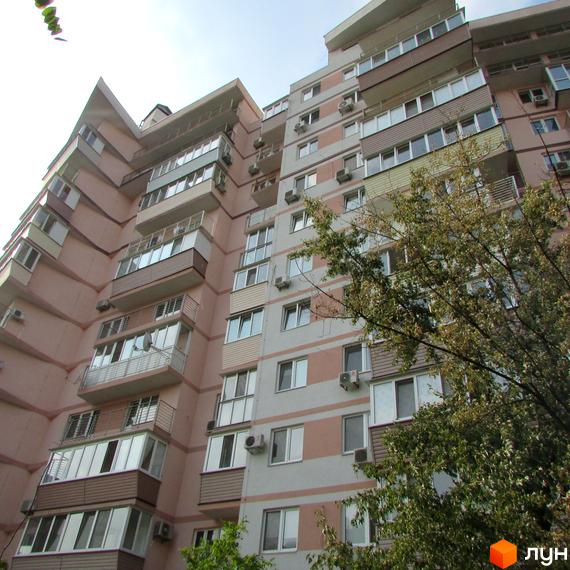 Житловий комплекс на вул. Януша Корчака, 25. Вид на фасад будинку з балконами та зеленими насадженнями на прибудинковій території.