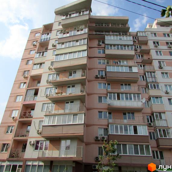 Житловий комплекс на вул. Януша Корчака, 25. Вид на фасад будинку з балконами та прибудинковою територією.