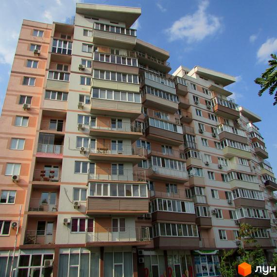 Житловий комплекс на вул. Януша Корчака, 25. Вид на фасад будинку з балконами та прибудинковою територією.