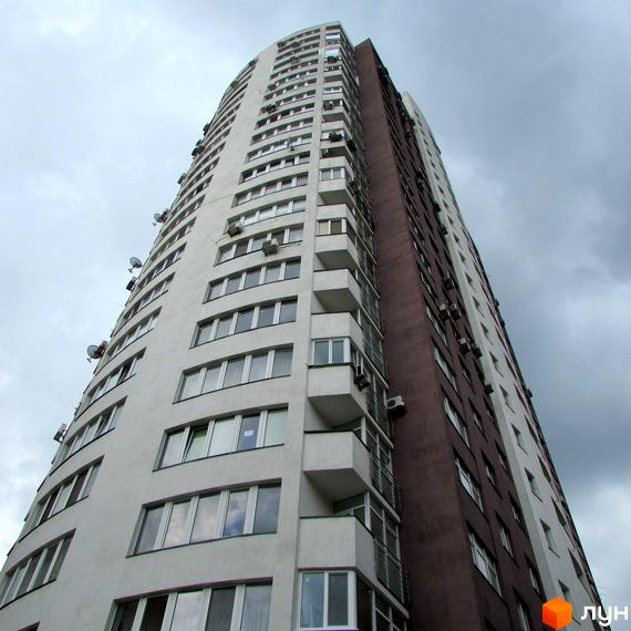 Житловий комплекс Вертикаль з висоти, фасад будинку з великими вікнами та балконами, облаштована прибудинкова територія.