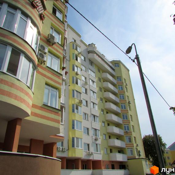 Житловий комплекс на вул. Козацька, 112-114 з сучасним фасадом та балконами. Прибудинкова територія з зеленими насадженнями.