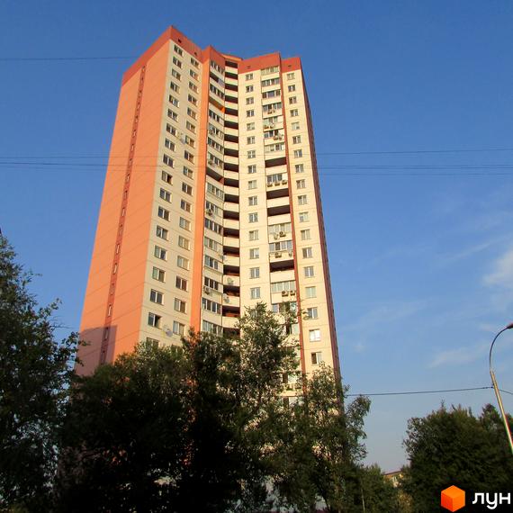 Вид на житловий комплекс Алма-Атинська, 109б з зеленими насадженнями на прибудинковій території. Високий будинок з балконами та великими вікнами.