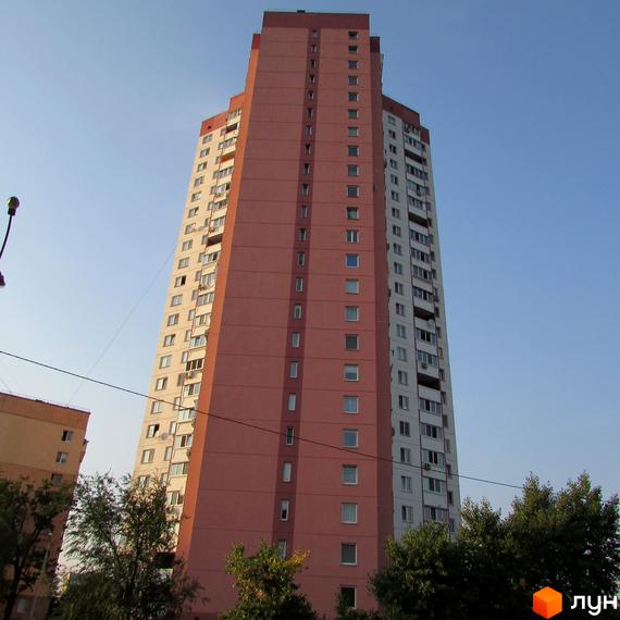 Висотний будинок житлового комплексу на вул. Алма-Атинська, 109б, з зеленими насадженнями біля під'їзду.