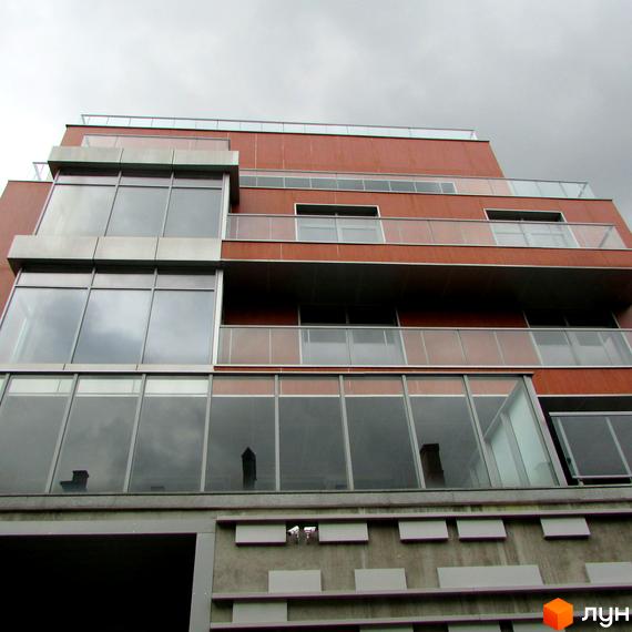 Сучасний зовнішній вигляд клубного будинку 'На Мічуріна' з великими вікнами та балконами. Прибудинкова територія з озелененням та зручним доступом.