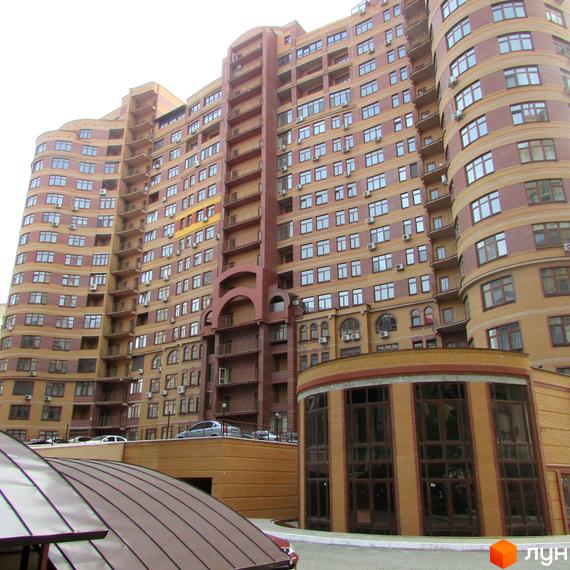 Житловий комплекс на вул. Євгена Коновальця, 36в, з фасадом з великими вікнами та прибудинковою територією.