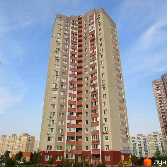 Високоповерховий житловий комплекс на просп. Григоренка, 12-14. Будинок має світло-сірий фасад з червоними вставками та балконами. На прибудинковій території видно дитячий майданчик та дерева.