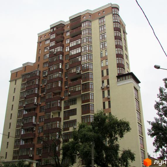 Висотна новобудова на вулиці Коперника, 11 з коричневими та світло-бежевими фасадами, численними балконами та великими вікнами. Навколо будинку ростуть дерева.