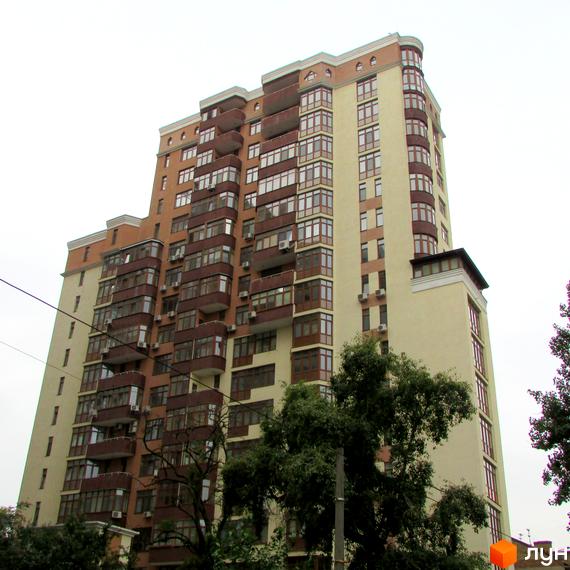 Новобудова на вул. Коперника, 11. Багатоповерховий будинок з коричневими та бежевими фасадами, численними балконами та лоджіями. Навколо будинку зелені дерева.