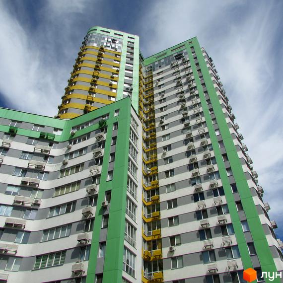 Житловий комплекс Паркове місто: високі будівлі з фасадами зеленого, сірого та жовтого кольорів, численними вікнами та кондиціонерами.