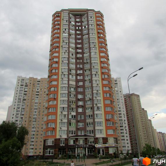 Житловий комплекс на вул. Урлівська, 40, з яскравим фасадом та прибудинковою територією, озелененою газонами.