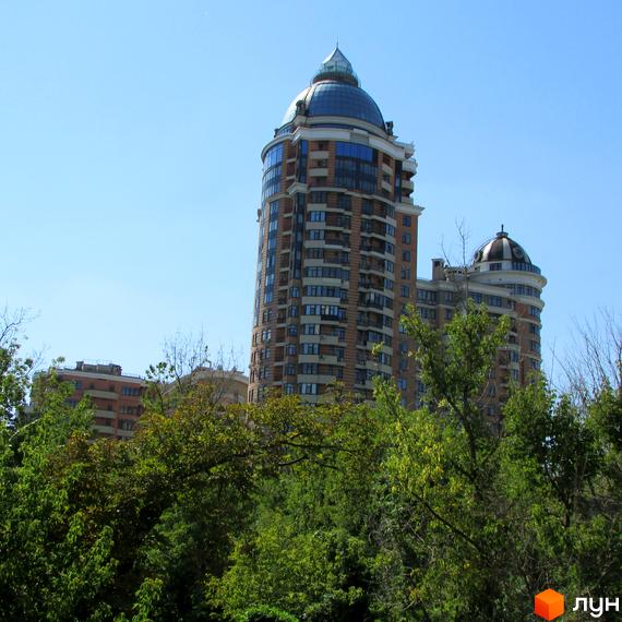 Житловий комплекс на бул. Лесі Українки, 7б, з сучасною архітектурою та зеленими насадженнями навколо.