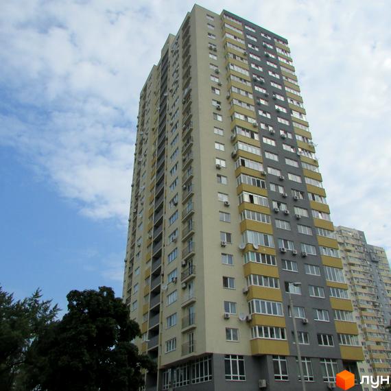 Висотний будинок житлового комплексу Перовський з балконами та великими вікнами, оточений зеленими насадженнями.