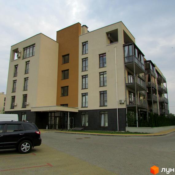 Зовнішній вигляд житлового комплексу Ліпінка з балконами та вхідною групою. Прибудинкова територія з паркувальними місцями та озелененням.