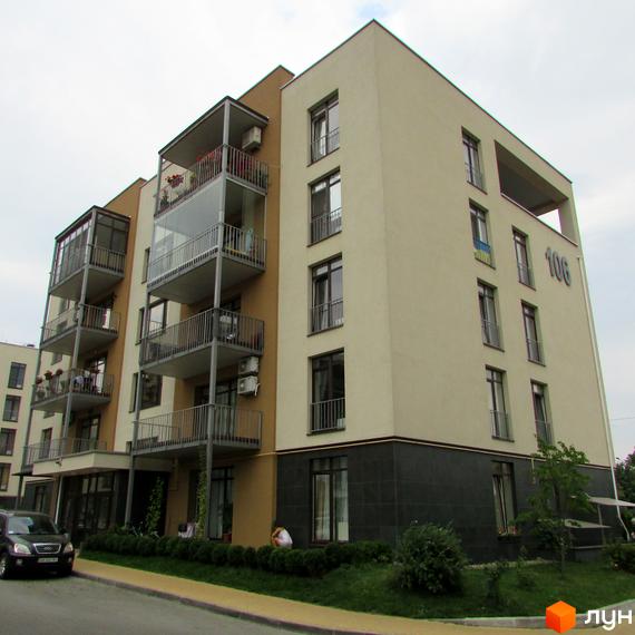 Житловий комплекс Ліпінка: багатоповерховий будинок з балконами та кондиціонерами. Прибудинкова територія з газоном та деревами.