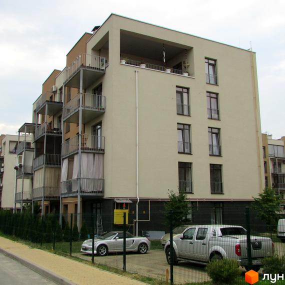 Житловий комплекс Ліпінка з балконами та вікнами, прибудинкова територія з автомобілями та зеленими насадженнями.