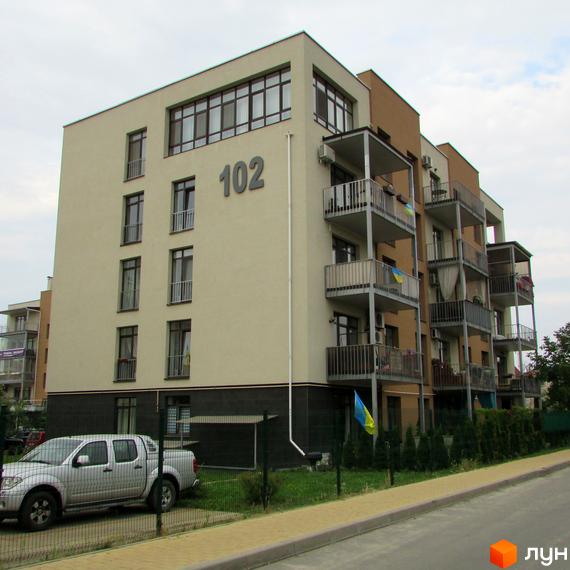 Житловий комплекс ЖК Ліпінка. Фасад будинку №102 з балконами та вікнами. Прибудинкова територія з автомобілем та огорожею.