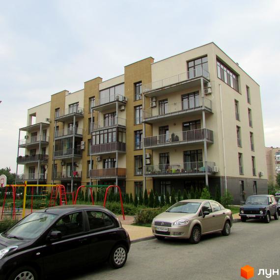 Житловий комплекс Ліпінка – багатоповерховий будинок з балконами та кондиціонерами, поруч дитячий майданчик та припарковані автомобілі.