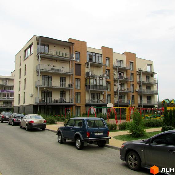 Зовнішній вигляд житлового комплексу Ліпінка з кількома секціями та балконами. Поряд розташований дитячий майданчик та припарковані автомобілі.